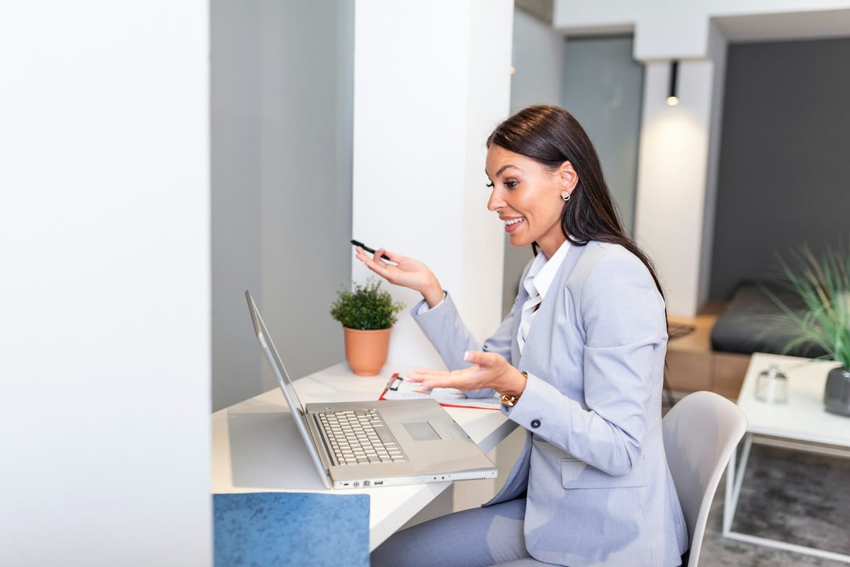 Femme d'affaires concentrée et souriante présentant en ligne